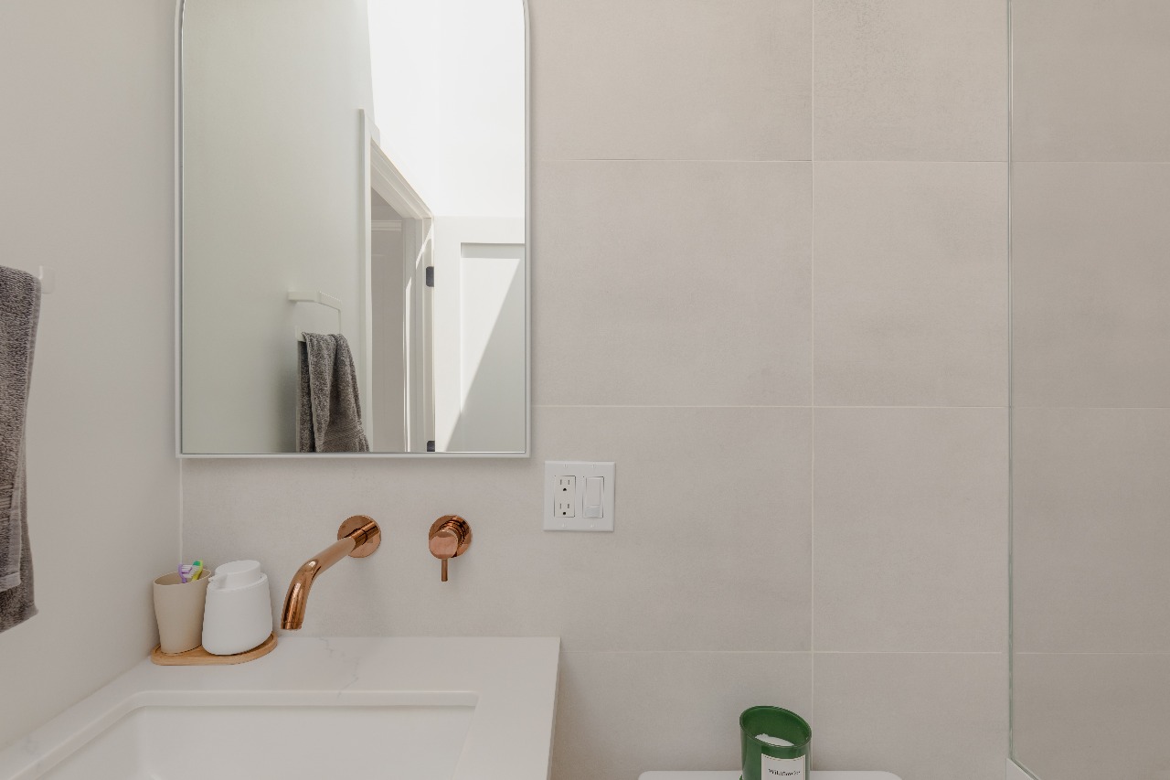 Bathroom with copper faucet and white tile in San Francisco full-house remodel
