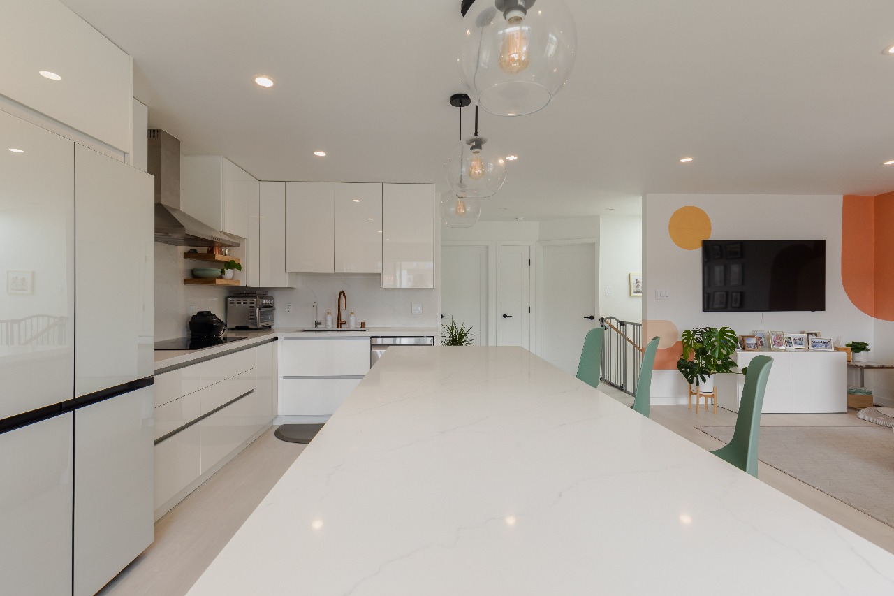 Kitchen with white cabinets, large island, and pendant lights in San Francisco full-house remodel