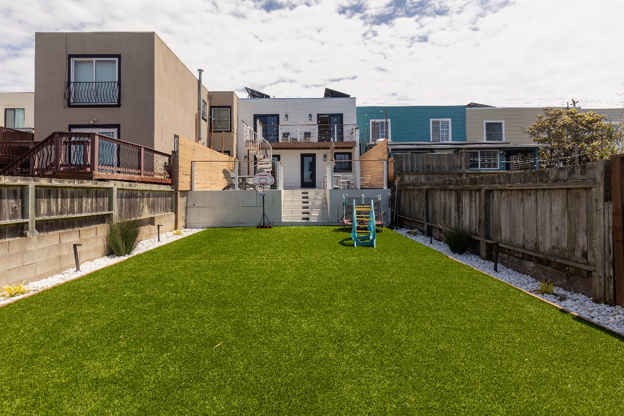 Backyard with artificial turf and wood fence in San Francisco full-house remodel
