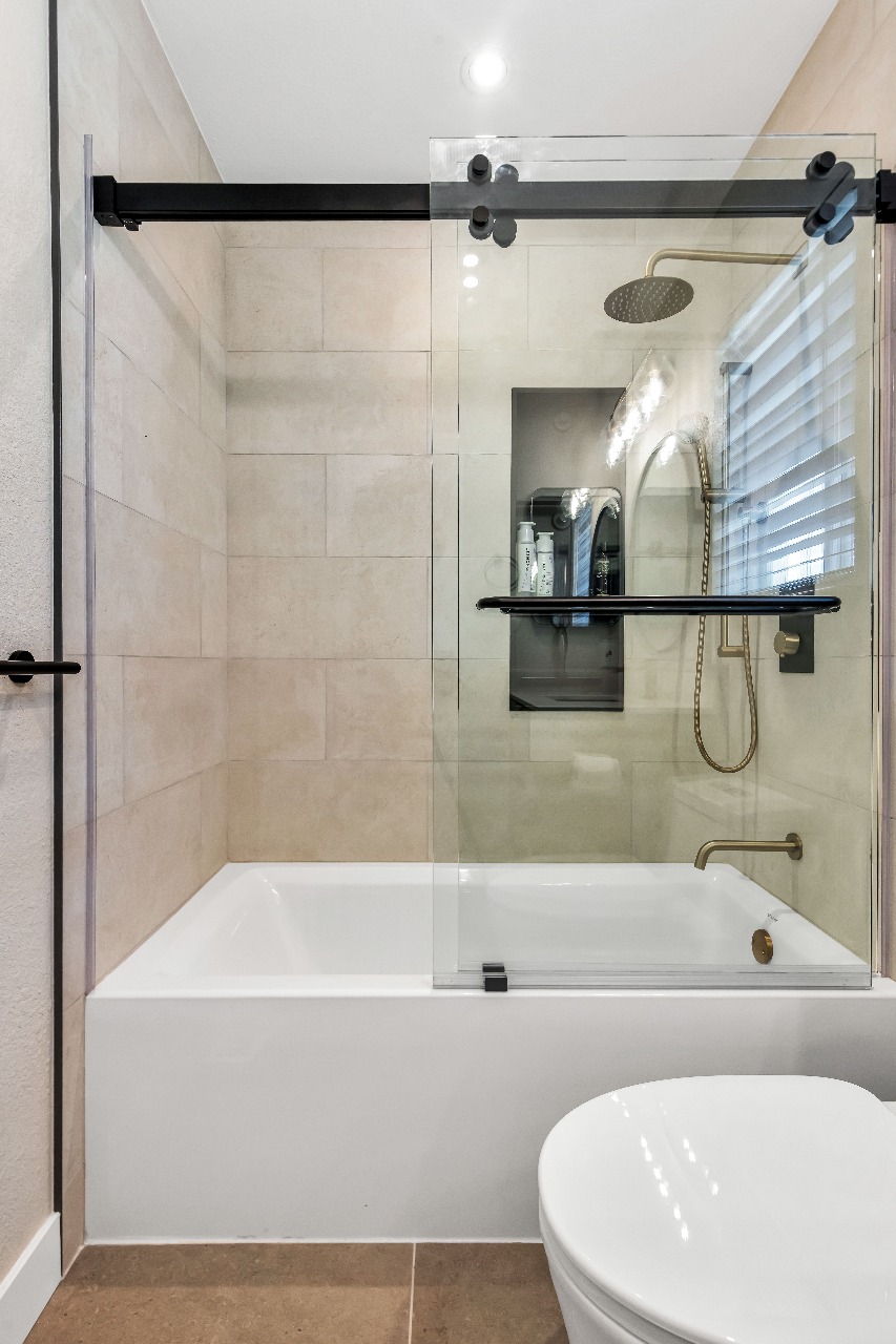 Bathroom with beige tile and glass shower in Alameda full-house remodel